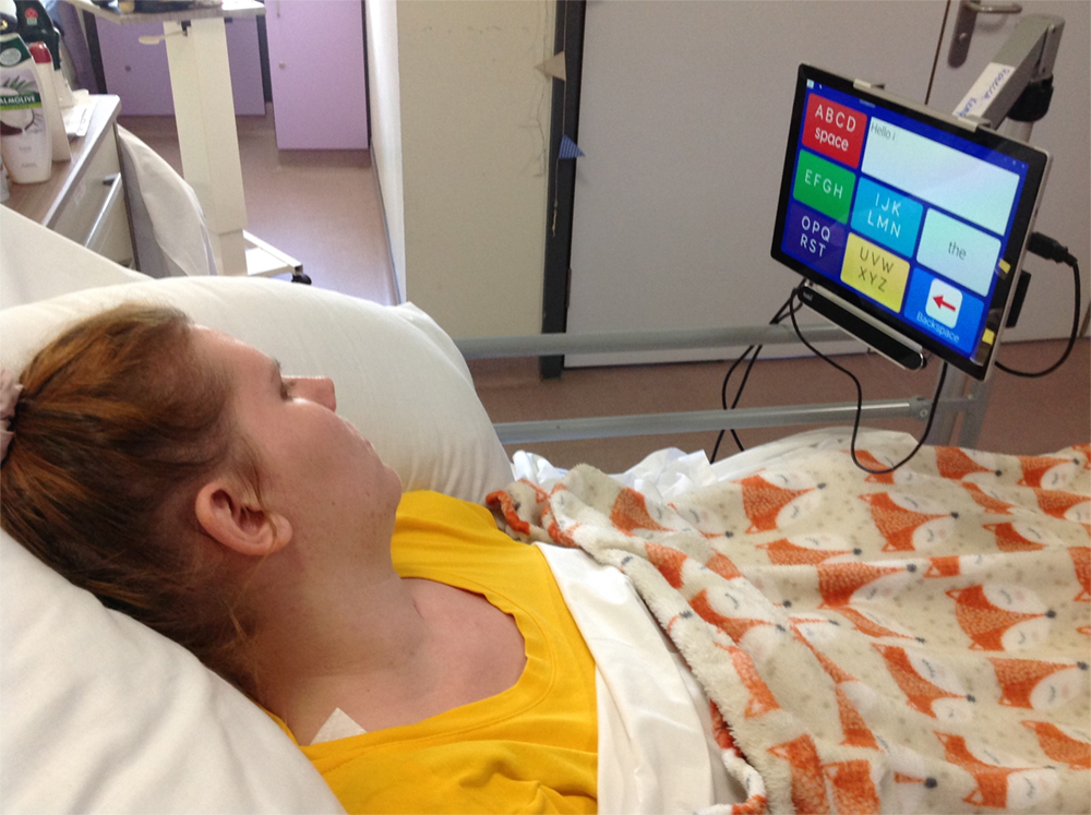 woman in bed looking at screen