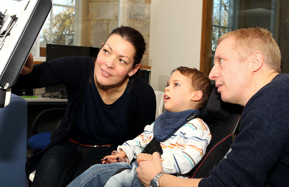 boy and parents looking at computer screen