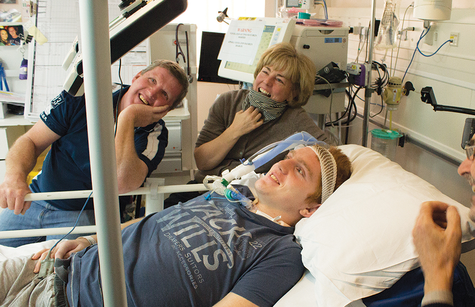 man lying in hospital bed using eye-controlled computer