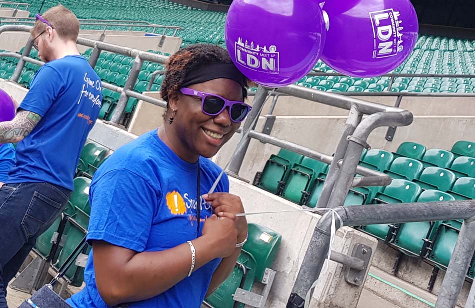 Woman in stadium holding balloons