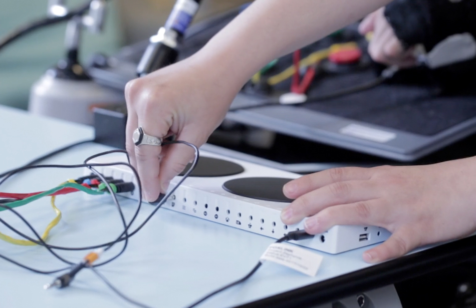 close up of hands plugging switches into adapted controller