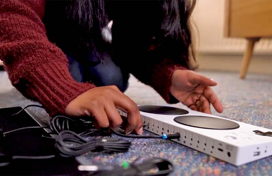 close up of hands plugging wires into adaptor