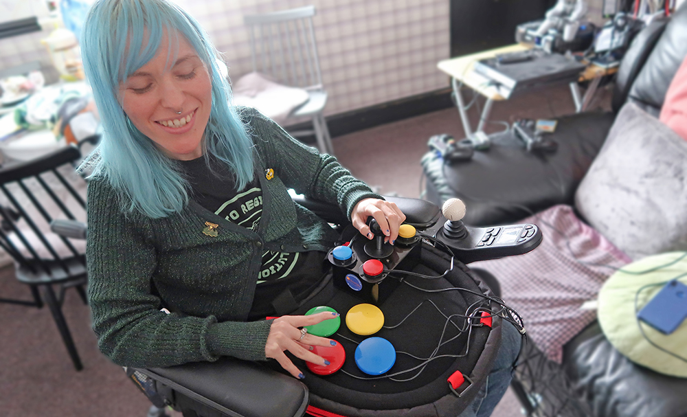 Seated girl using adapted games controller