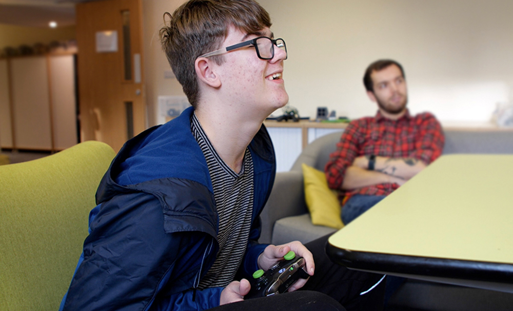smiling seated man using games controller