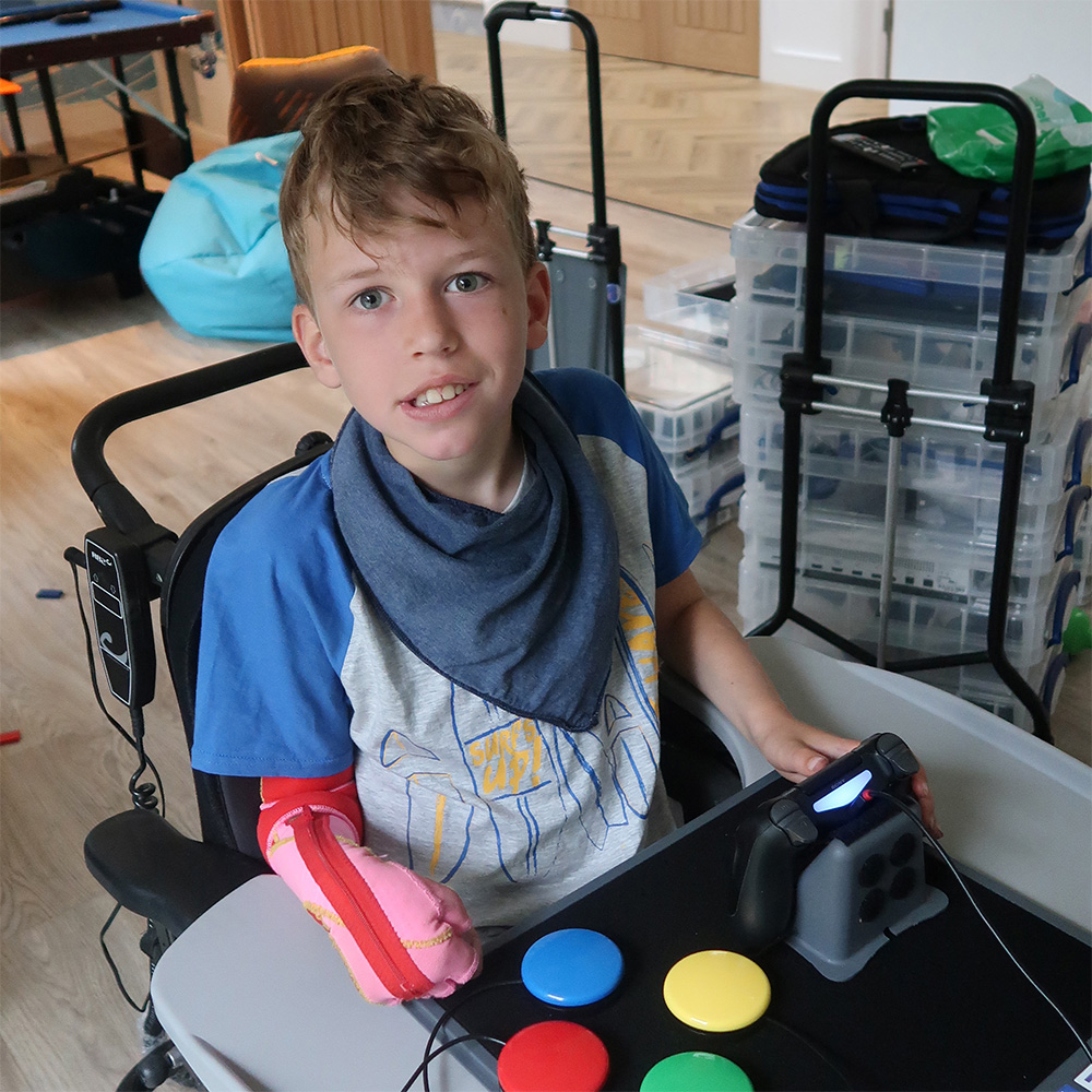 Boy in wheelchair with adapted joystick and four button switches