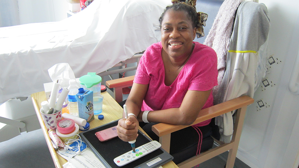 Seated smiling woman operating remote control