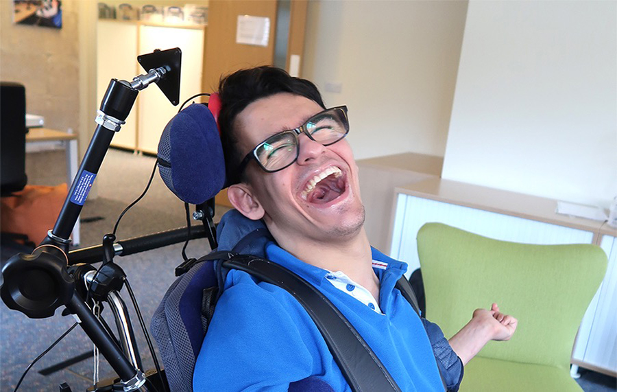 headshot of smiling man in wheelchair using headswitch
