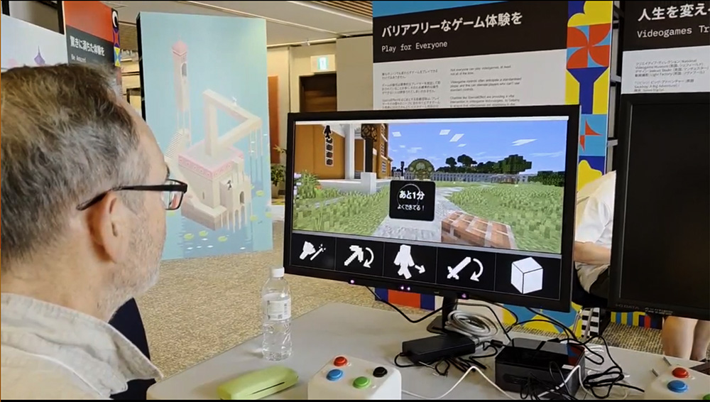 Man in an expo hall looking at a Minecraft screen with a strip of eye-control selectable icons at the bottom