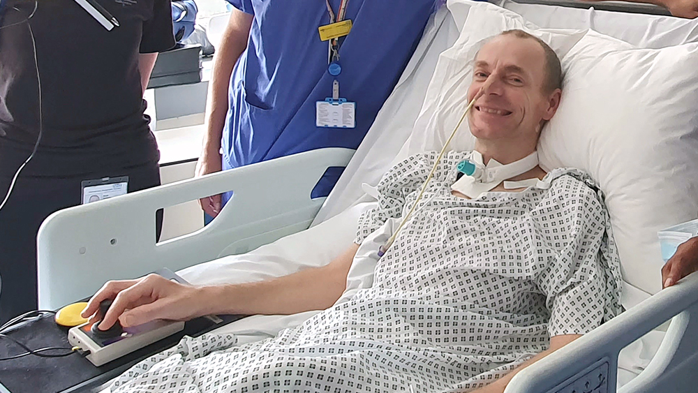 Smiling man sitting up in a hospital bed