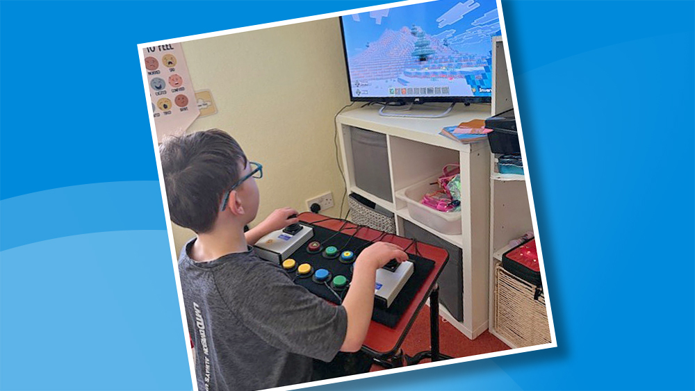 Boy playing Minecraft using an an adapted gaming controller setup