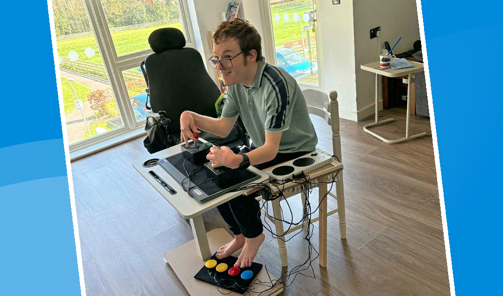Seated young man using a game controller setup with large joysticks and foot switches 