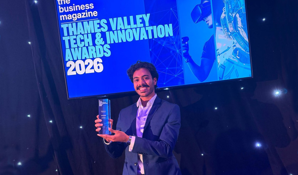 Smiling man on stage holding up an award